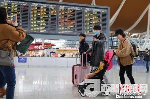旅客帶著孩子前往辦票柜臺(tái)辦理登機(jī)手續(xù)?！∫罅⑶?攝