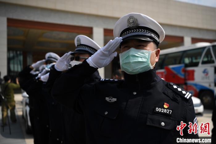 圖為交警們向醫(yī)療隊敬禮?！】灯?攝