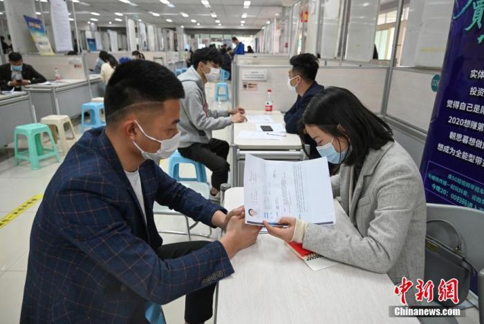 4月14日，招聘者在查看求職者簡(jiǎn)歷。<a target='_blank'  data-cke-saved- >中新社</a>記者 王剛 攝