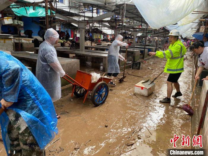 圖為7月26日，暴雨引發(fā)的洪水過境后，重慶萬州區(qū)分水鎮(zhèn)政府干部職工及志愿者清掃淤泥和垃圾。　　重慶萬州區(qū)委宣傳部供圖 攝