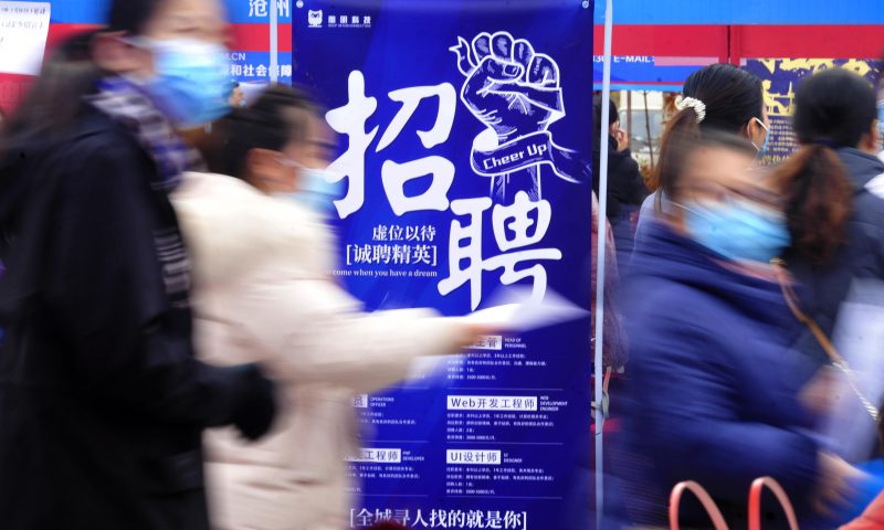 求職者從一家招聘企業(yè)的廣告牌前走過。新華社發(fā)（苑立偉 攝）